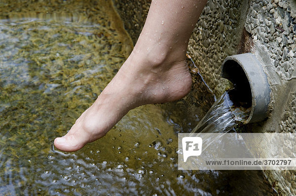 Nackter Fuß einer Seniorin über einem Wasserbecken