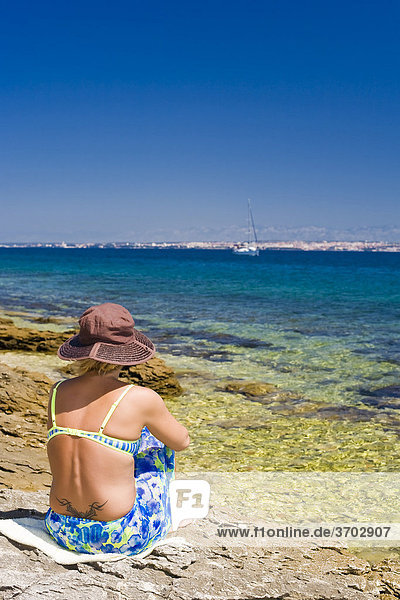 Frau mit Hut sitzt am Meer mit Blick auf Zadar  Insel Ugljan  Zadar  Dalmatien  Kroatien  Europa