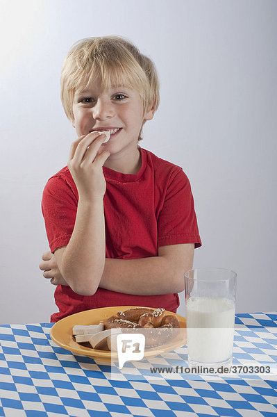 Junge 4-5 Jahre isst Breze und Gelbwurst