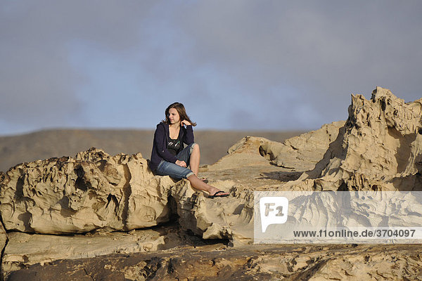 Junge Frau auf Kalkgesteinsablagerungen  La Pared  Fuerteventura  Kanarische Inseln  Spanien  Europa