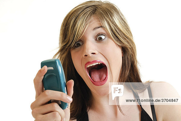 Young woman screaming while holding a cellphone in her hand