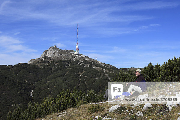 Rastende Wanderer vor Dobratsch-Gipfel mit Sendemast und Kirche Maria am Stein  Villacher Alpe  Kärnten  Österreich  Europa