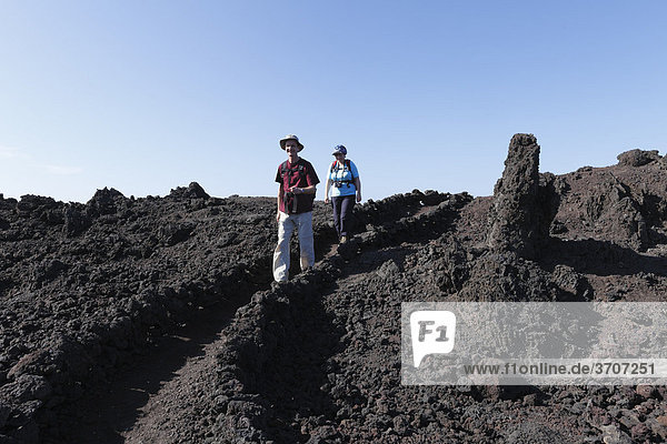 Hikers on the coast in Timanfaya National Park  Lanzarote  Canary Islands  Spain  Europe