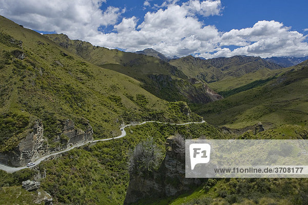 Geschlängelter Sandweg im grün bewachsenen Skippers Canyon Queenstown Südinsel Neuseeland
