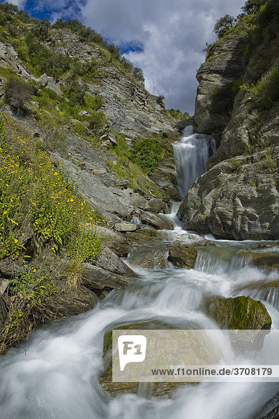 Gebirgsbach mit einem Wasserfall im Skippers Canyon Queenstown Südinsel Neuseeland
