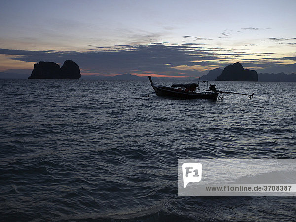 Long tail boats at dawn with a group of rocks off Ko Hai island  Ko Ngai  Andaman Sea  Satun Province  southern Thailand  Thailand  Asia