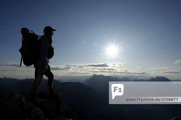 Mountain climber in front of alpine peaks at sunrise  Berwang  Tyrol  Ausserfern  Austria  Europe