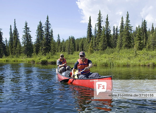 Zwei junge Männer fahren im Kanu  paddeln  oberer Liard River Fluss  Caribou Creek  Yukon Territory  Kanada