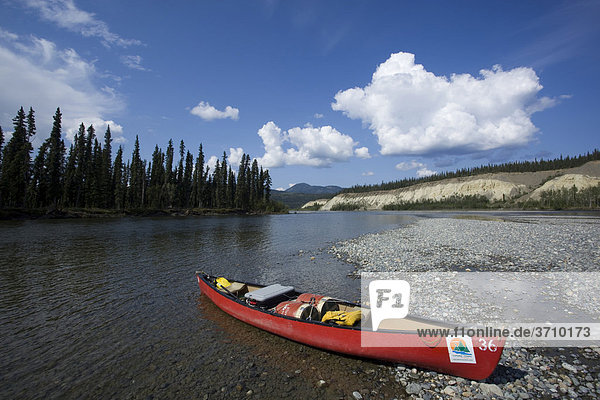 Beladenes Kanu auf einer Kiesbank  Teslin River  Erosionslandschaft  hohe Uferböschung  Yukon Territory  Kanada