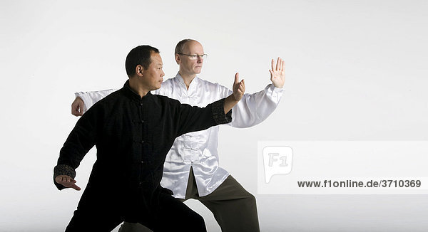 Deutsch-chinesische Freundschaft  zwei Taiji Meister in klassischer Taiji Bewegung  Chansi Gong  Westeuropa trifft Asien  in traditionellen Taiji-Jacken