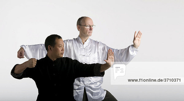 Deutsch-chinesische Freundschaft zwei Taiji Meister in klassischer Taiji Bewegung Chansi Gong Westeuropa trifft Asien in traditionellen Taiji-Jacken