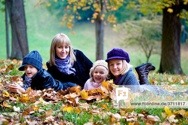 Mother and three children in a park in autumn