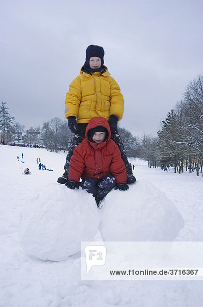 Two boys on big snoww balls