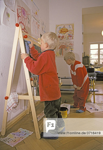 Fünfjähriger Junge beim Malen an einer Staffelei