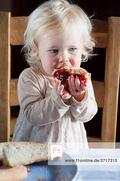Weibliches Kleinkind beim Brot und Marmelade essen