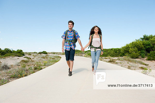Young couple walking down rural road