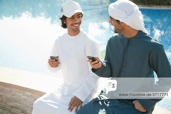 Zwei Männer aus dem Nahen Osten mit Mobiltelefonen