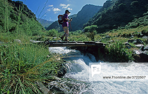 Hiker on bridge Rio Poqueira Andalusia Province Granada Sierra Nevada Alpujarras  Alpujarras  Spain