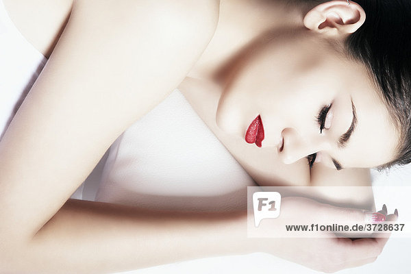 Young dark-haired woman lying with eyes closed  portrait mouth