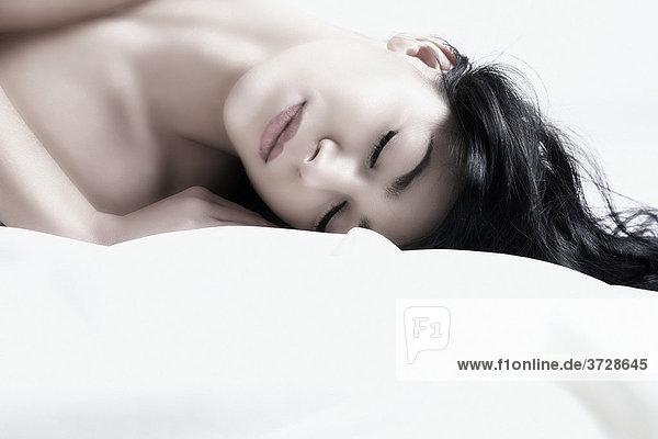 Young dark-haired woman lying with eyes closed  portrait