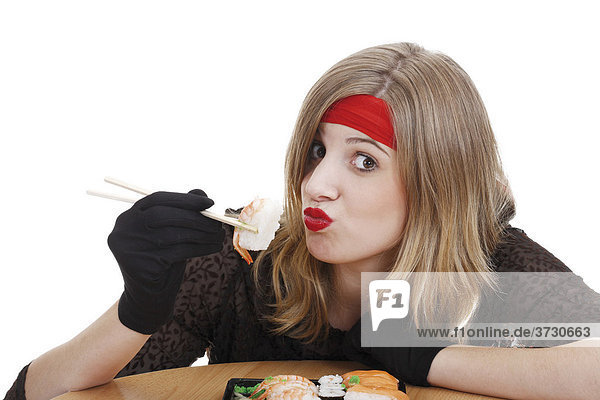 Junge Frau isst Sushi mit Stäbchen