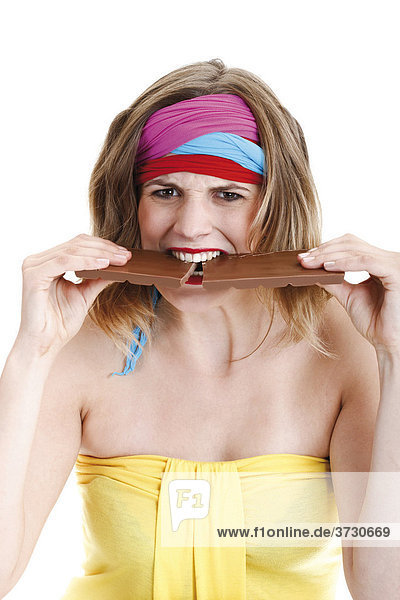 Junge Frau beißt auf Tafel Schokolade