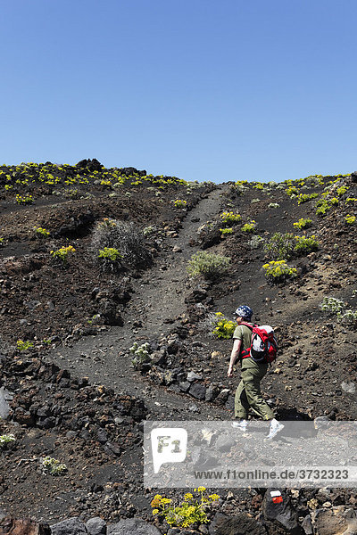Frau mit Rucksack wandert auf Wanderweg bei Vulkan TeneguÌa  La Palma  Kanaren  Kanarische Inseln  Spanien  Europa