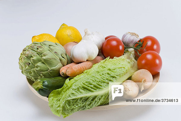 Holzschale mit verschiedenen Gemüsesorten und Salat