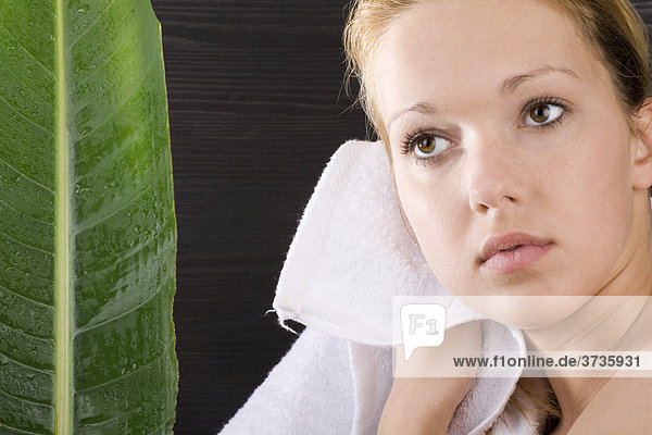 Junge Frau tocknet nasse Haare mit Handtuch
