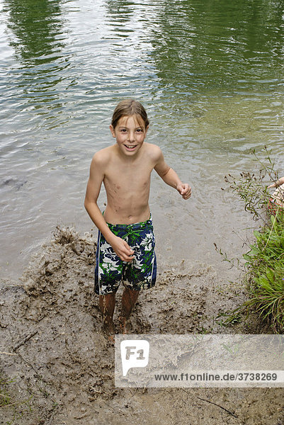 Boy splashing around in muddy water