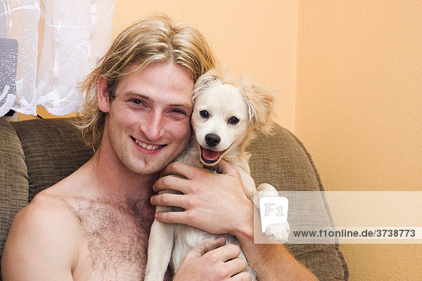 Smiling blond man  25 years  and his smiling dog