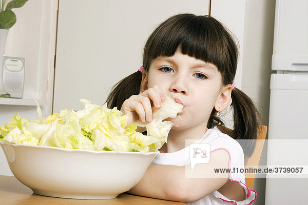 Kleines Mädchen  6 Jahre  isst Salat  drinnen