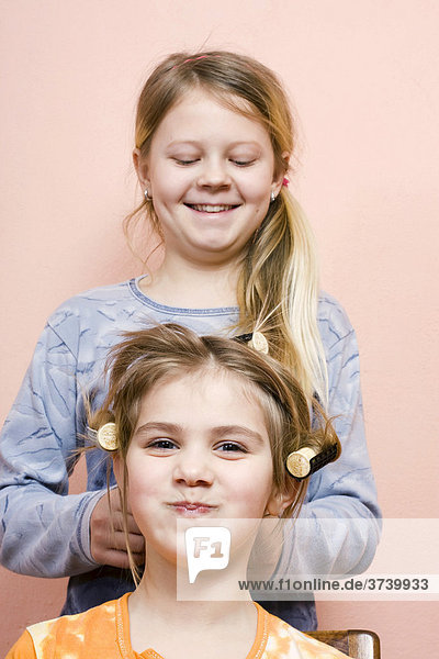 Zwei Mädchen 11 und 6 Jahre spielen Friseur