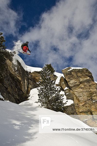 Tiefschnee Skifahrer  Freerider  beim Sprung über Felswand