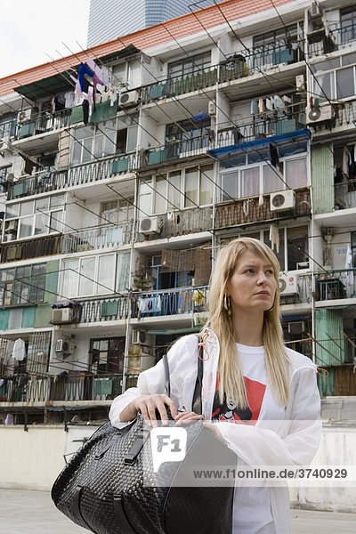 Junge Frau vor Wohnkomplex  Shanghai  China  Asien