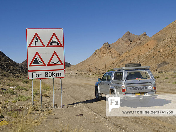 Warntafel und Geländewagen Toyota Hilux an der C13 nördlich von Rosh Pinah  Namibia  Afrika