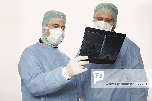 Zwei Chirurgen beurteilen eine Röntgenaufnahme