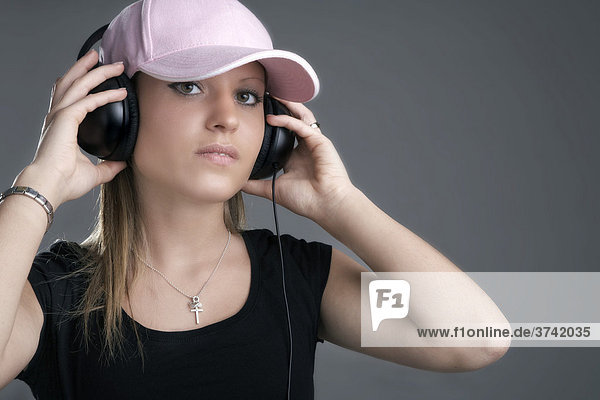 Young woman wearing headphones and a baseball cap