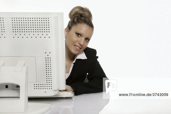Business woman sitting behind a computer  smiling