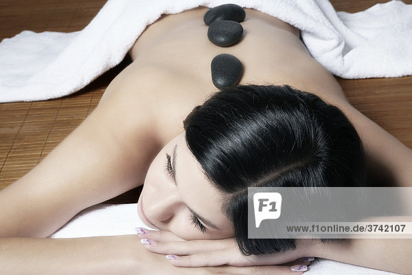 Hot Stone Therapy performed on a dark haired young woman