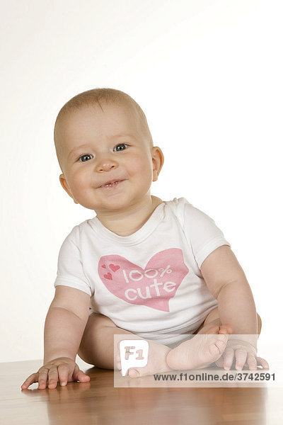Baby  6 Monate  sitzt und lächelt