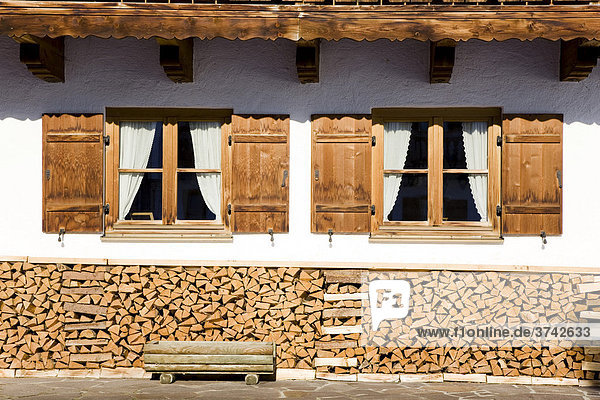 Fenster eines Bauernhauses mit Holzstapel  Bayern  Deutschland  Europa