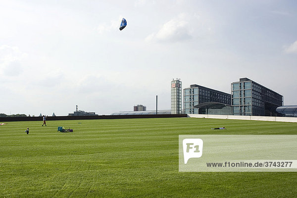 People on a meadow flying kites in front of the central station of Berlin  Germany  Europe