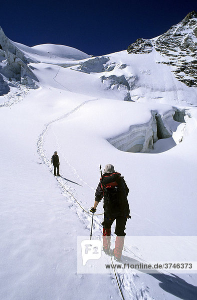 Two mountaineers ascending Mount Piz Glueschaint  Bernina Range  Graubuenden Canton  Switzerland  Europe
