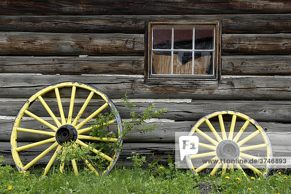 Gelbgestrichene Wagenräder vor einem Blockhaus historisches Dorf Barkerville British Columbia Kanada Nordamerika