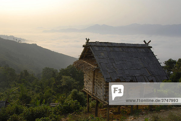 Hütte für Vorrat aus Bambus der Akha Meuo Ethnie in traditionellem Bergdorf Ban Chakhampa mit Blick auf den Nebel im Tal  Phongsali Provinz  Laos  Südostasien