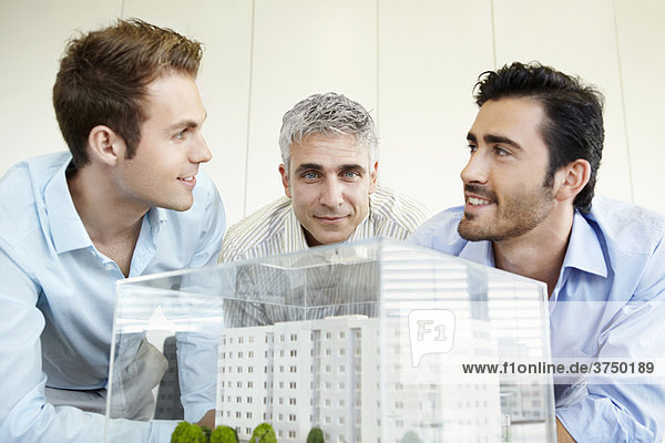 3 Männer diskutieren über das Architekturmodell