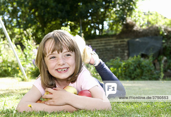 Happy girl in garden with apples