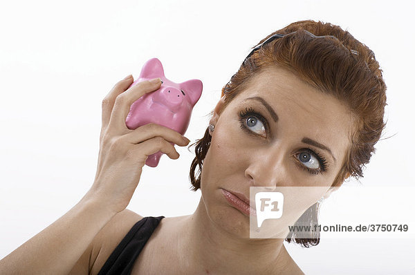 Woman listening to a piggy bank