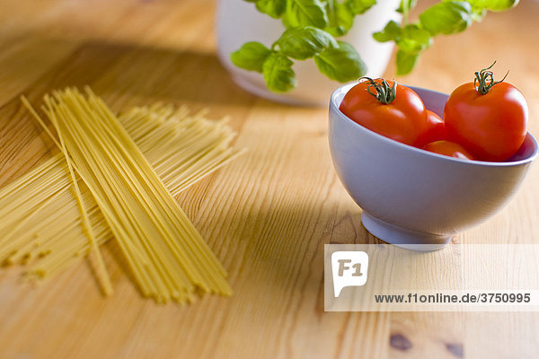 Tomaten in einer Schüssel mit Basilikum und Spaghetti